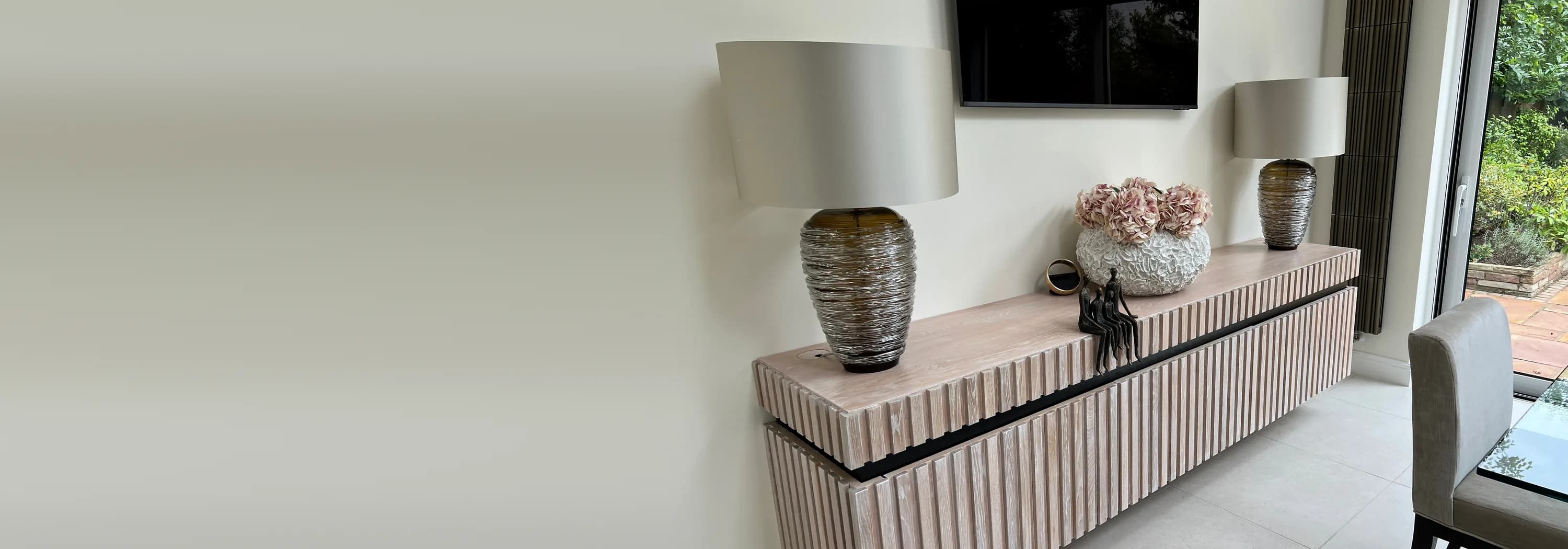 A floating limed oak sideboard with fluted fronts, made by Neil, in a bright garden room